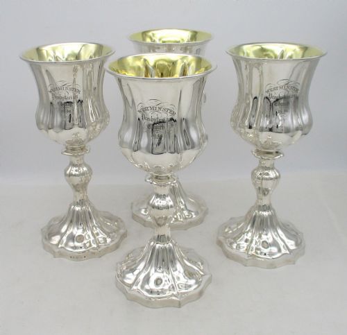 fig 2. A seven-piece silver-plated Victorian communion set featuring two tall lidded flagons, four chalices with gilded interiors, and a shaped waiter tray with church inscriptions.