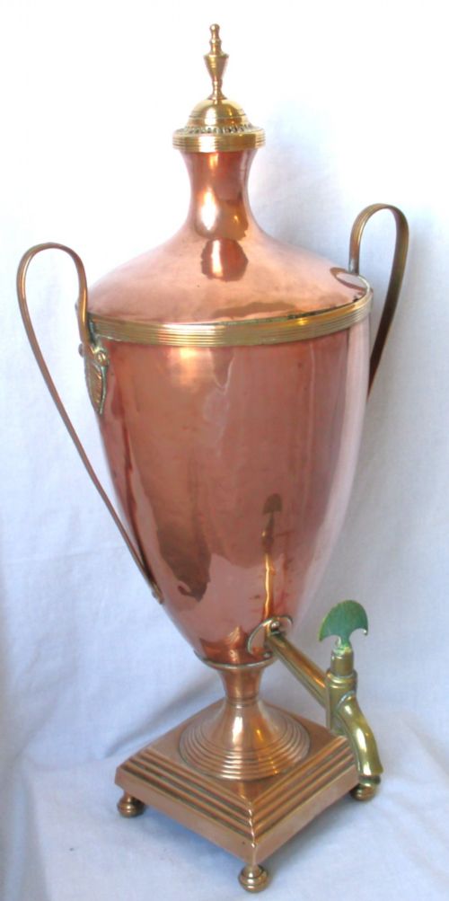 An early nineteenth-century copper tea urn featuring loop handles, a brass spigot, a decorative finial, and a square stepped pedestal base. View II