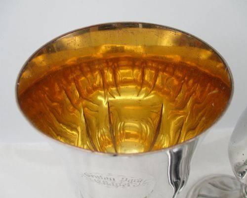 fig 1. A pair of silver-plated Old Sheffield chalices featuring fluted lower bowls, raised lobed bases, and gilded interiors engraved with chapel inscriptions.