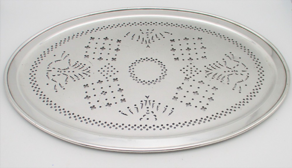 An oval 19th-century silver-plated mazarine draining tray featuring intricate pierced geometric patterns and foliate scrollwork.