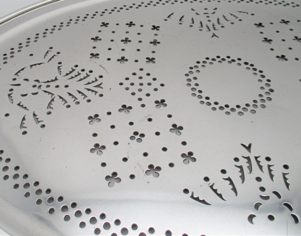 An oval 19th-century silver-plated mazarine draining tray featuring intricate pierced geometric patterns and foliate scrollwork. View V
