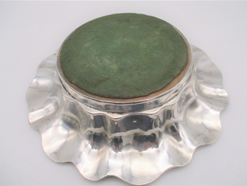 A pair of circular silver-plated wine coasters featuring scalloped rims decorated with grapevine and foliage relief details around concentric circular turned bases. View IX