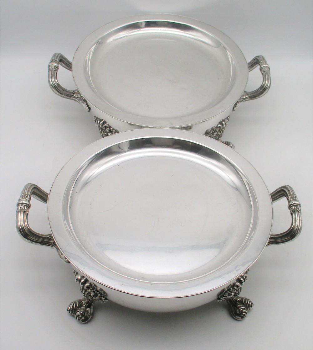 A pair of 19th-century circular silver-plated warming dishes featuring twin handles and ornate cast feet. View III