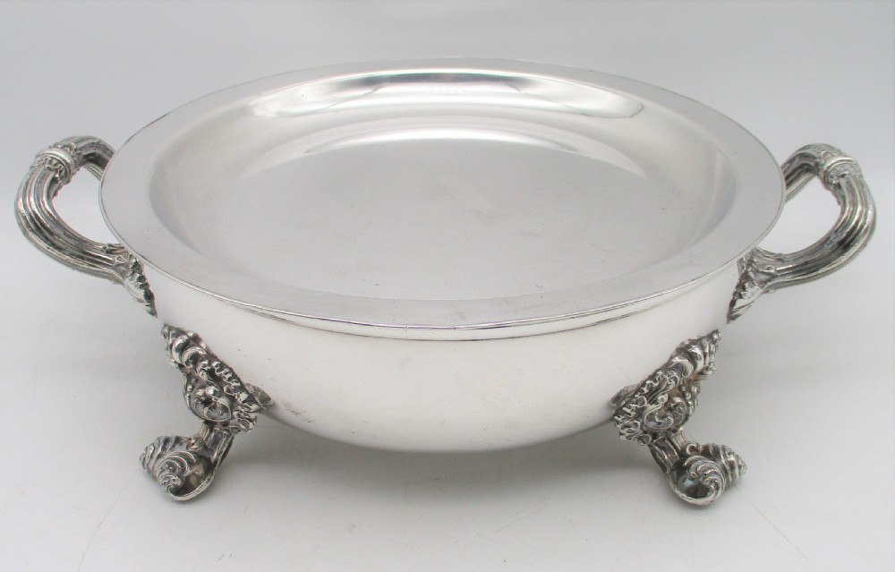 A pair of 19th-century circular silver-plated warming dishes featuring twin handles and ornate cast feet. View IV