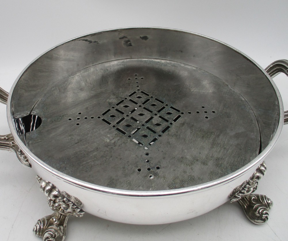 A pair of 19th-century circular silver-plated warming dishes featuring twin handles and ornate cast feet. View VII
