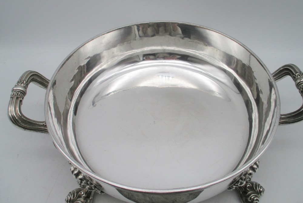A pair of 19th-century circular silver-plated warming dishes featuring twin handles and ornate cast feet. View VIII