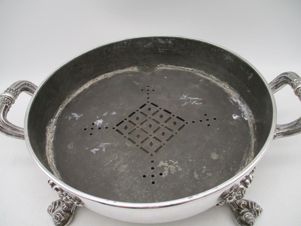 A pair of 19th-century circular silver-plated warming dishes featuring twin handles and ornate cast feet. View X