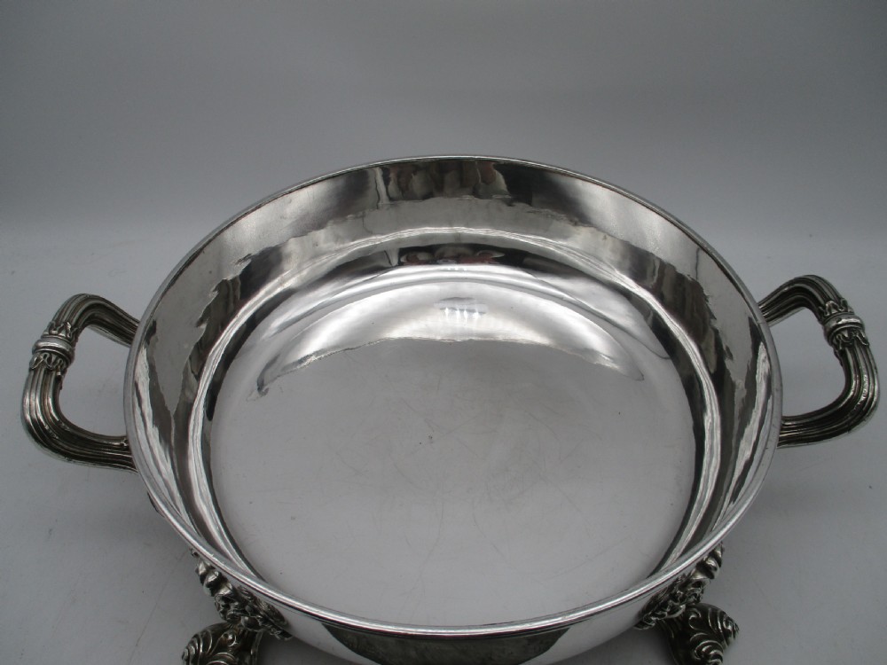 A pair of 19th-century circular silver-plated warming dishes featuring twin handles and ornate cast feet. View XI