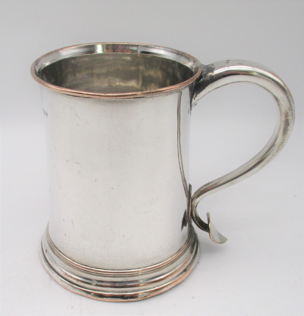 An 18th-century Old Sheffield silver-plated pint tankard with a curved handle and visible copper exposure along the rim and base.