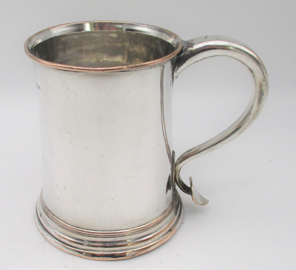 An 18th-century Old Sheffield silver-plated pint tankard with a curved handle and visible copper exposure along the rim and base. View II