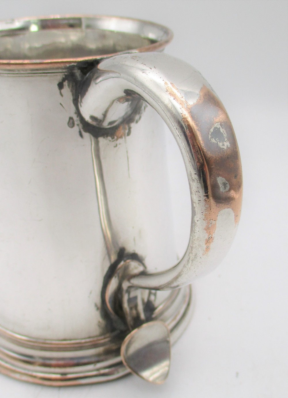 An 18th-century Old Sheffield silver-plated pint tankard with a curved handle and visible copper exposure along the rim and base. View III
