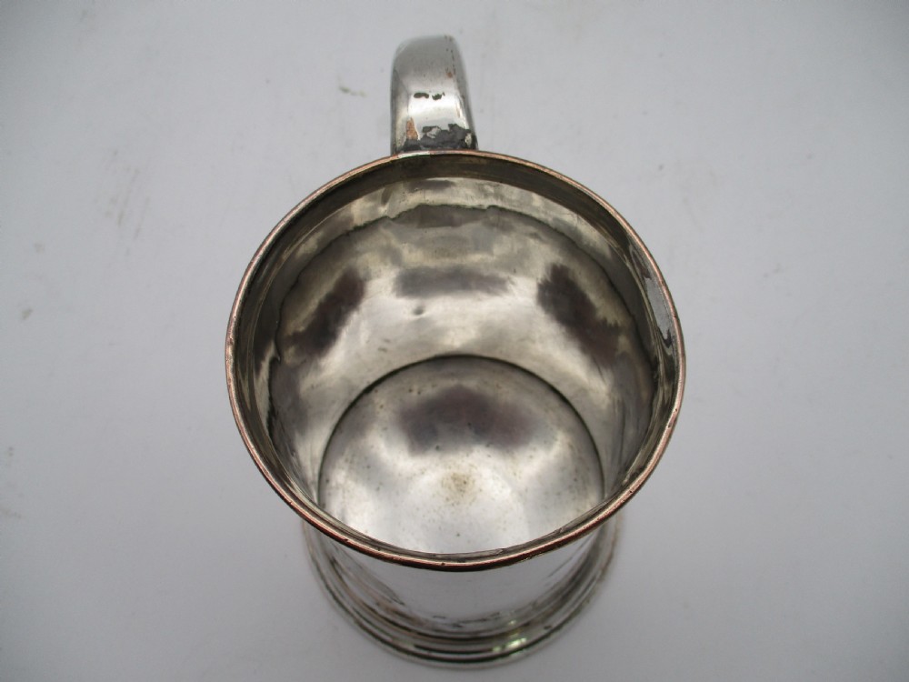An 18th-century Old Sheffield silver-plated pint tankard with a curved handle and visible copper exposure along the rim and base. View VIII