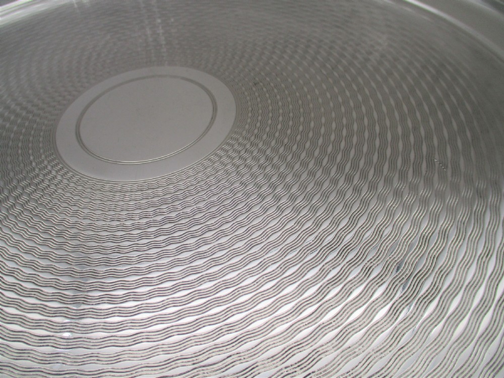 A round silver-plated cocktail tray with engine-turned concentric patterning and an unengraved central circular cartouche. View II