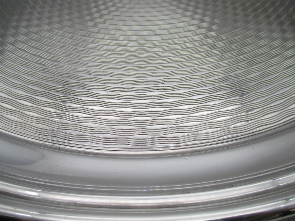 A round silver-plated cocktail tray with engine-turned concentric patterning and an unengraved central circular cartouche. View III
