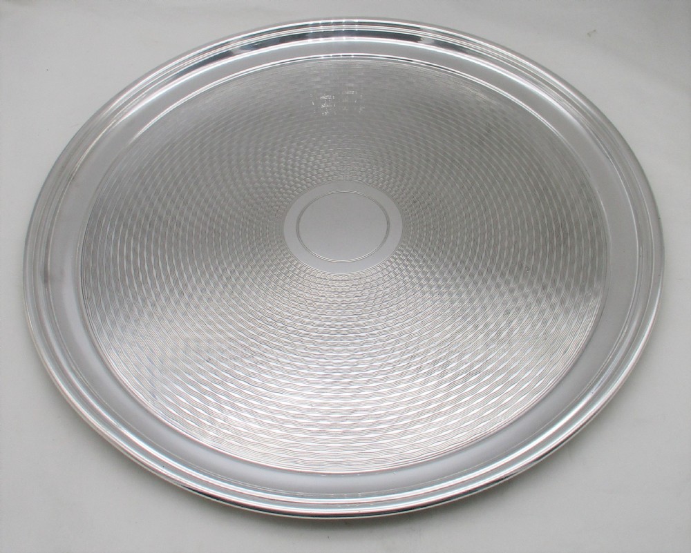 A round silver-plated cocktail tray with engine-turned concentric patterning and an unengraved central circular cartouche. View VIII
