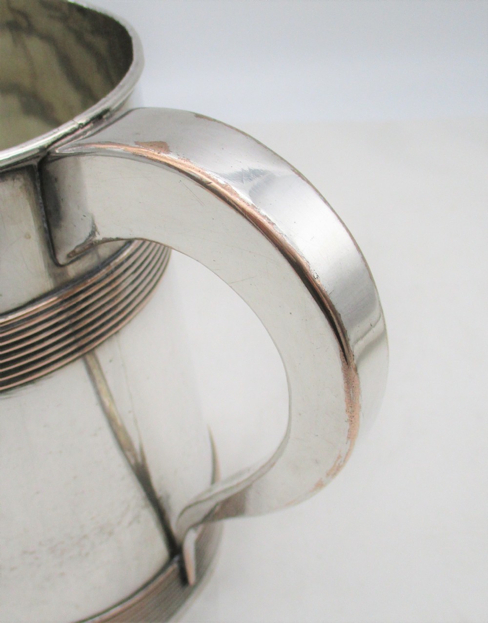 A Georgian Old Sheffield silver-plated quart tankard featuring a tapered body with reeded copper bands and a curved handle. View II