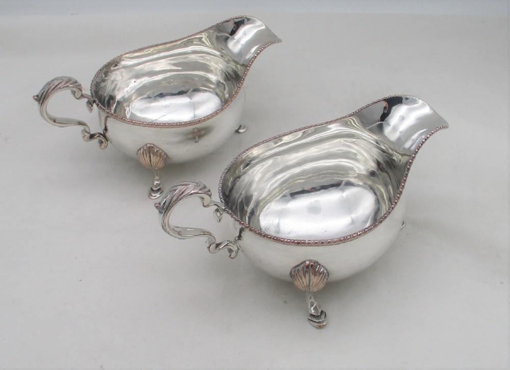 A pair of silver-plated sauce boats featuring double-scroll handles, gadrooned rims, and shell-capped feet. View II