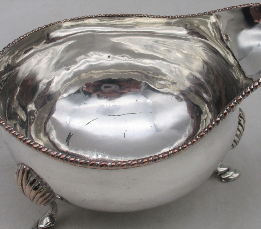 A pair of silver-plated sauce boats featuring double-scroll handles, gadrooned rims, and shell-capped feet. View V