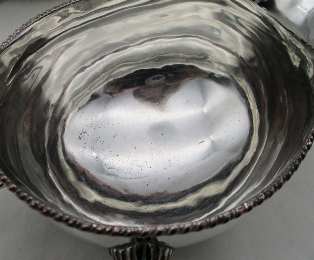 A pair of silver-plated sauce boats featuring double-scroll handles, gadrooned rims, and shell-capped feet. View VI