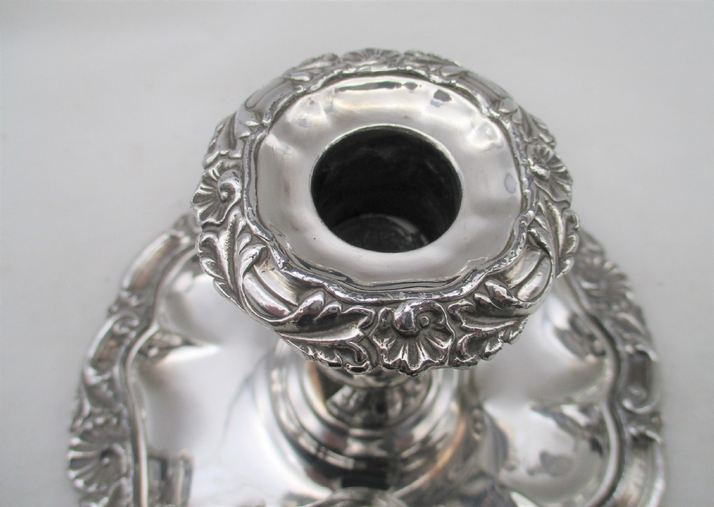 A 19th-century silver-plated chamber stick featuring a scalloped rim, central sconce, engraved crest on the dish, and a fitted conical snuffer. View V
