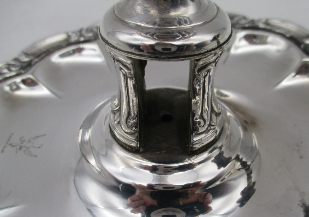 A 19th-century silver-plated chamber stick featuring a scalloped rim, central sconce, engraved crest on the dish, and a fitted conical snuffer. View VII