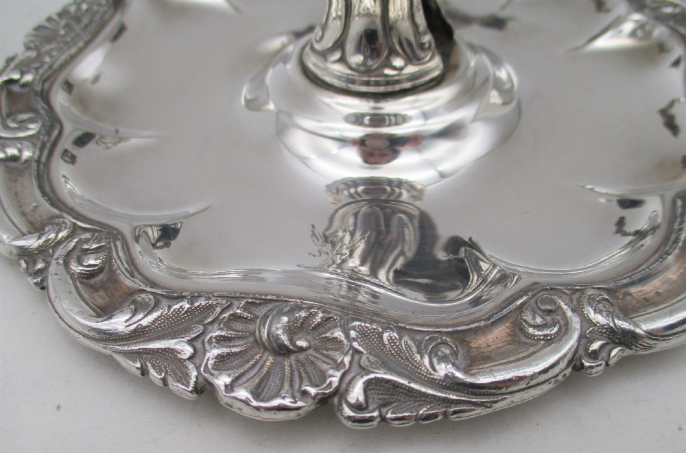 A 19th-century silver-plated chamber stick featuring a scalloped rim, central sconce, engraved crest on the dish, and a fitted conical snuffer. View VIII