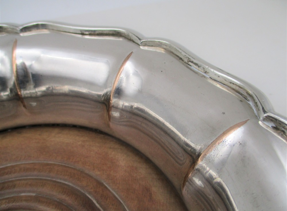 A set of three silver-plated wine bottle coasters with scalloped rims and turned wood bases. View XI