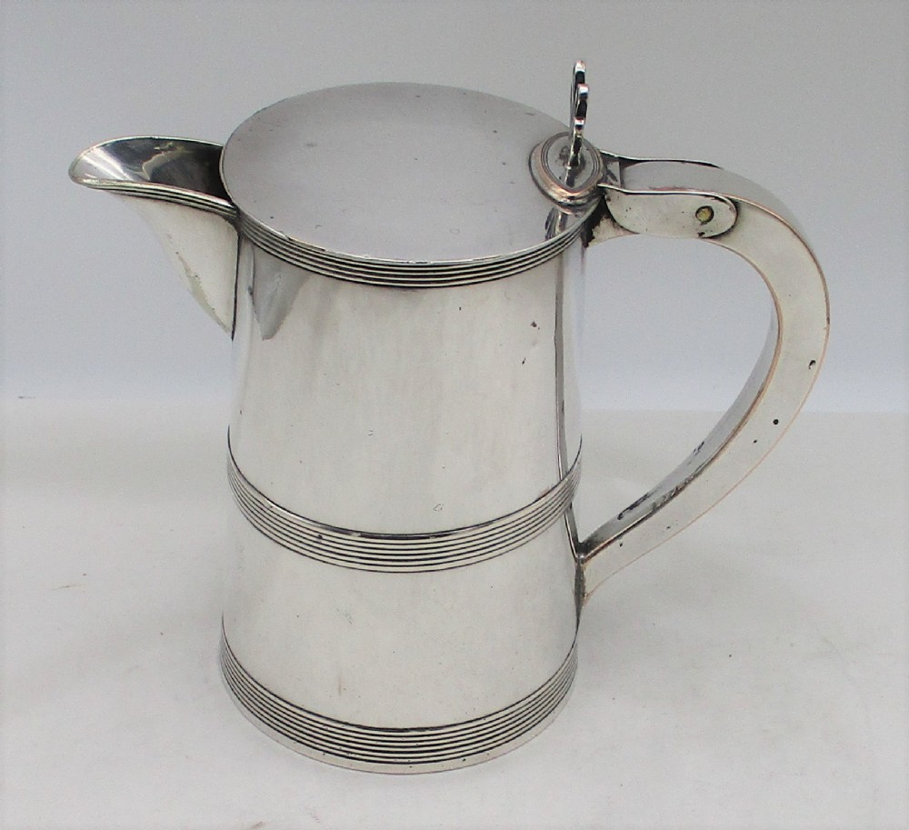 A 19th-century silver-plated beer jug with a hinged lid, reeded horizontal bands, and a sturdy curved handle.