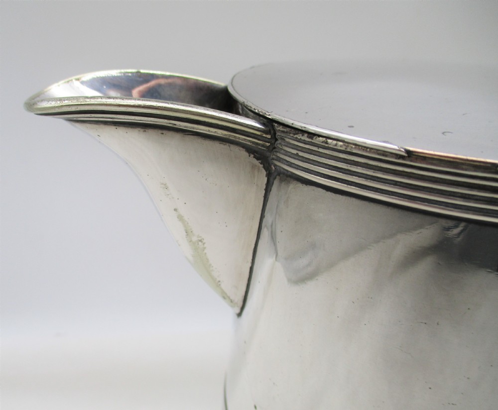 A 19th-century silver-plated beer jug with a hinged lid, reeded horizontal bands, and a sturdy curved handle. View IV
