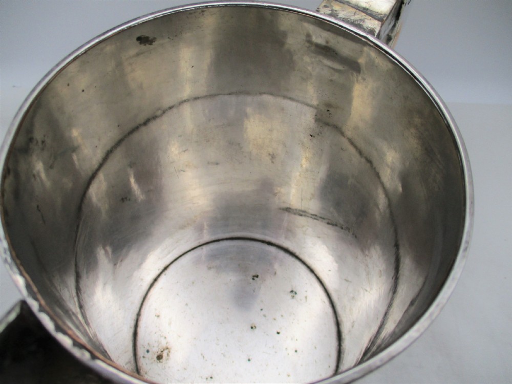 A 19th-century silver-plated beer jug with a hinged lid, reeded horizontal bands, and a sturdy curved handle. View VI