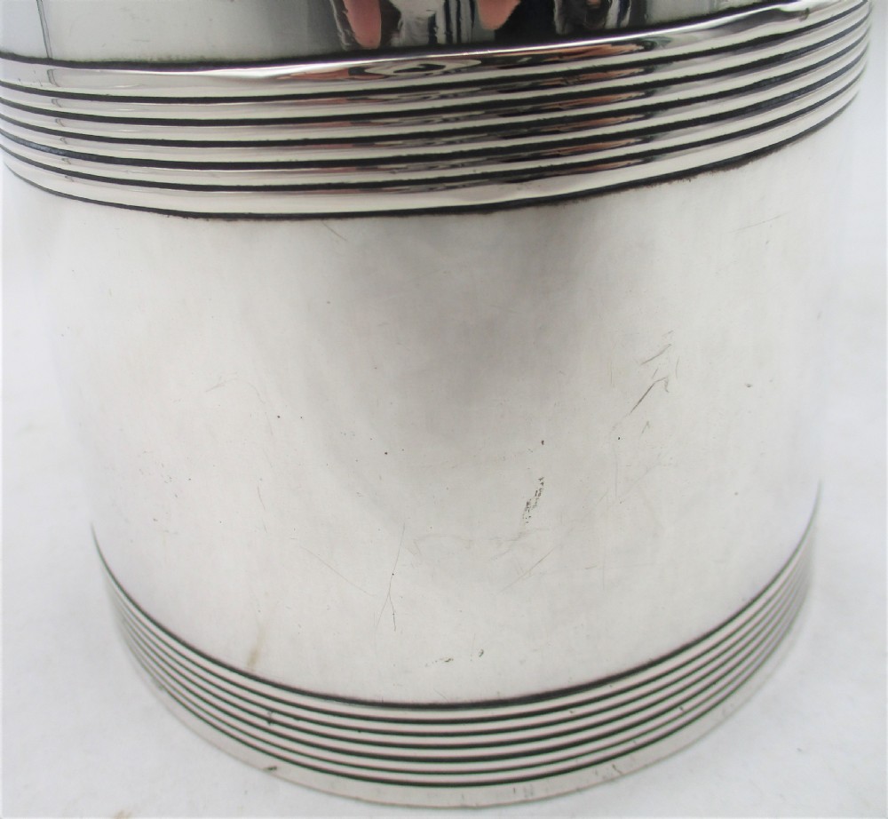 A 19th-century silver-plated beer jug with a hinged lid, reeded horizontal bands, and a sturdy curved handle. View VII