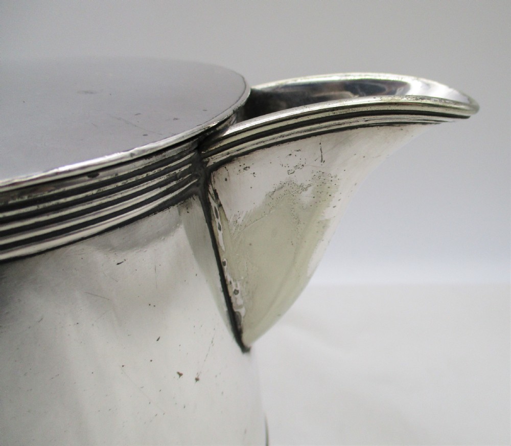 A 19th-century silver-plated beer jug with a hinged lid, reeded horizontal bands, and a sturdy curved handle. View IX