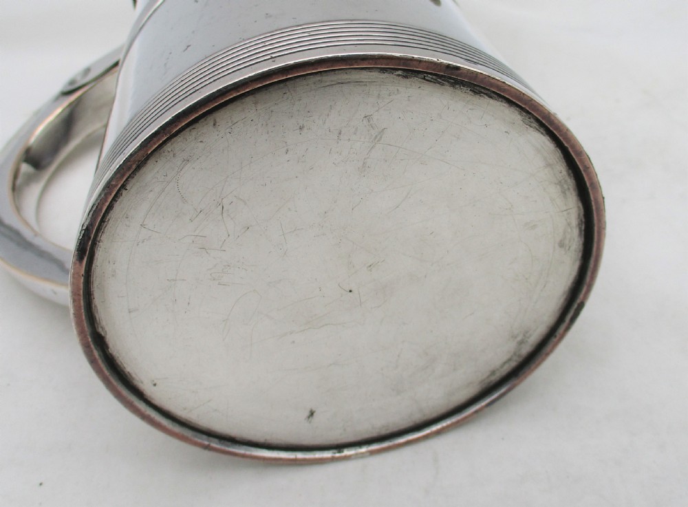 A 19th-century silver-plated beer jug with a hinged lid, reeded horizontal bands, and a sturdy curved handle. View X