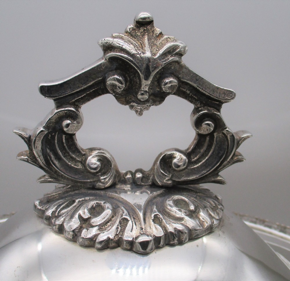 A large 19th-century silver-plated soup tureen featuring leaf-form handles, a domed lid with a scroll finial, and four scroll feet. View III
