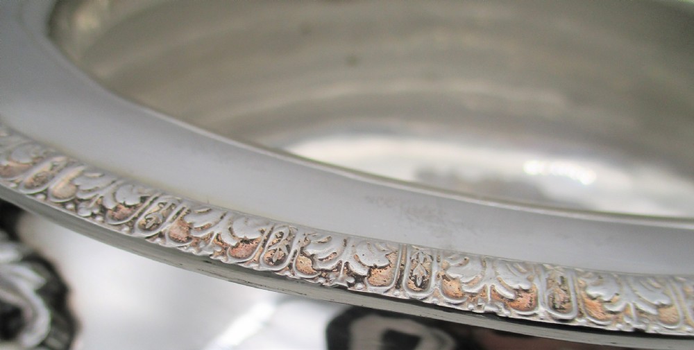 A large 19th-century silver-plated soup tureen featuring leaf-form handles, a domed lid with a scroll finial, and four scroll feet. View VI