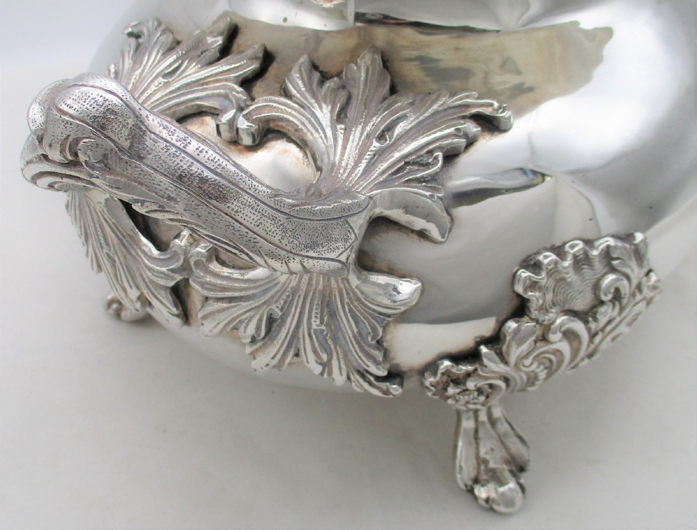 A large 19th-century silver-plated soup tureen featuring leaf-form handles, a domed lid with a scroll finial, and four scroll feet. View VII