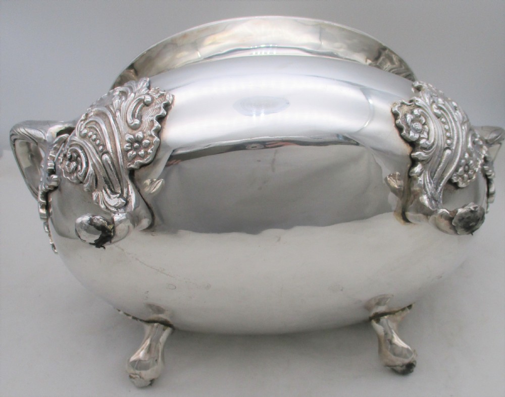 A large 19th-century silver-plated soup tureen featuring leaf-form handles, a domed lid with a scroll finial, and four scroll feet. View IX