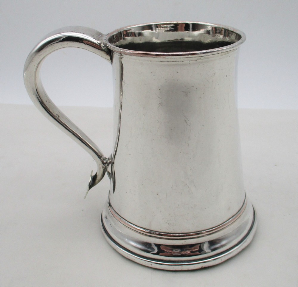 An 18th-century silver-plated pint tankard with a tapered body, curved strap handle, and a stepped circular base. View III