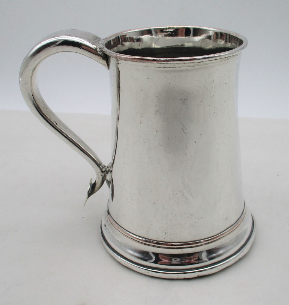 An 18th-century silver-plated pint tankard with a tapered body, curved strap handle, and a stepped circular base. View IV