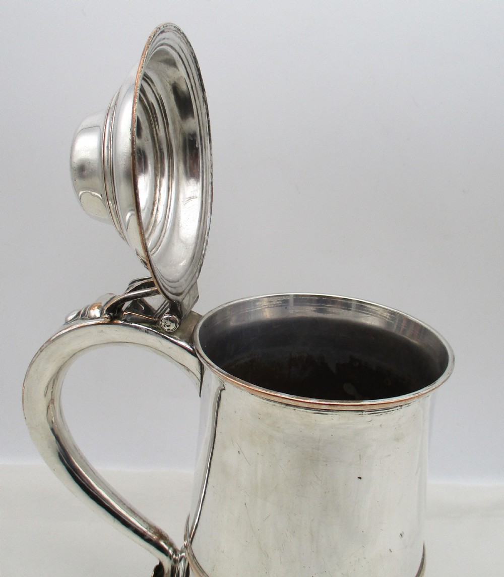 An 18th-century Old Sheffield plated silver quart tankard featuring a domed lid, thumbpiece, scroll handle, and visible copper bleeding along the moulded edges. View VII