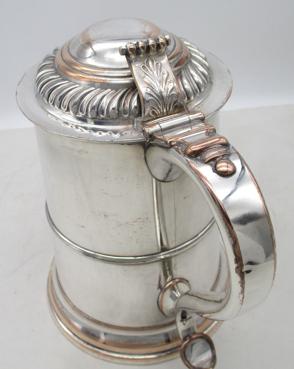 A Georgian Old Sheffield plated silver tankard featuring a domed gadrooned lid, sturdy scroll handle, and subtle copper show-through along the base. View II