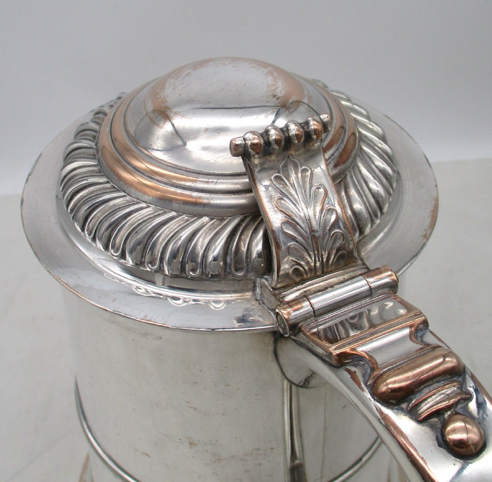 A Georgian Old Sheffield plated silver tankard featuring a domed gadrooned lid, sturdy scroll handle, and subtle copper show-through along the base. View III