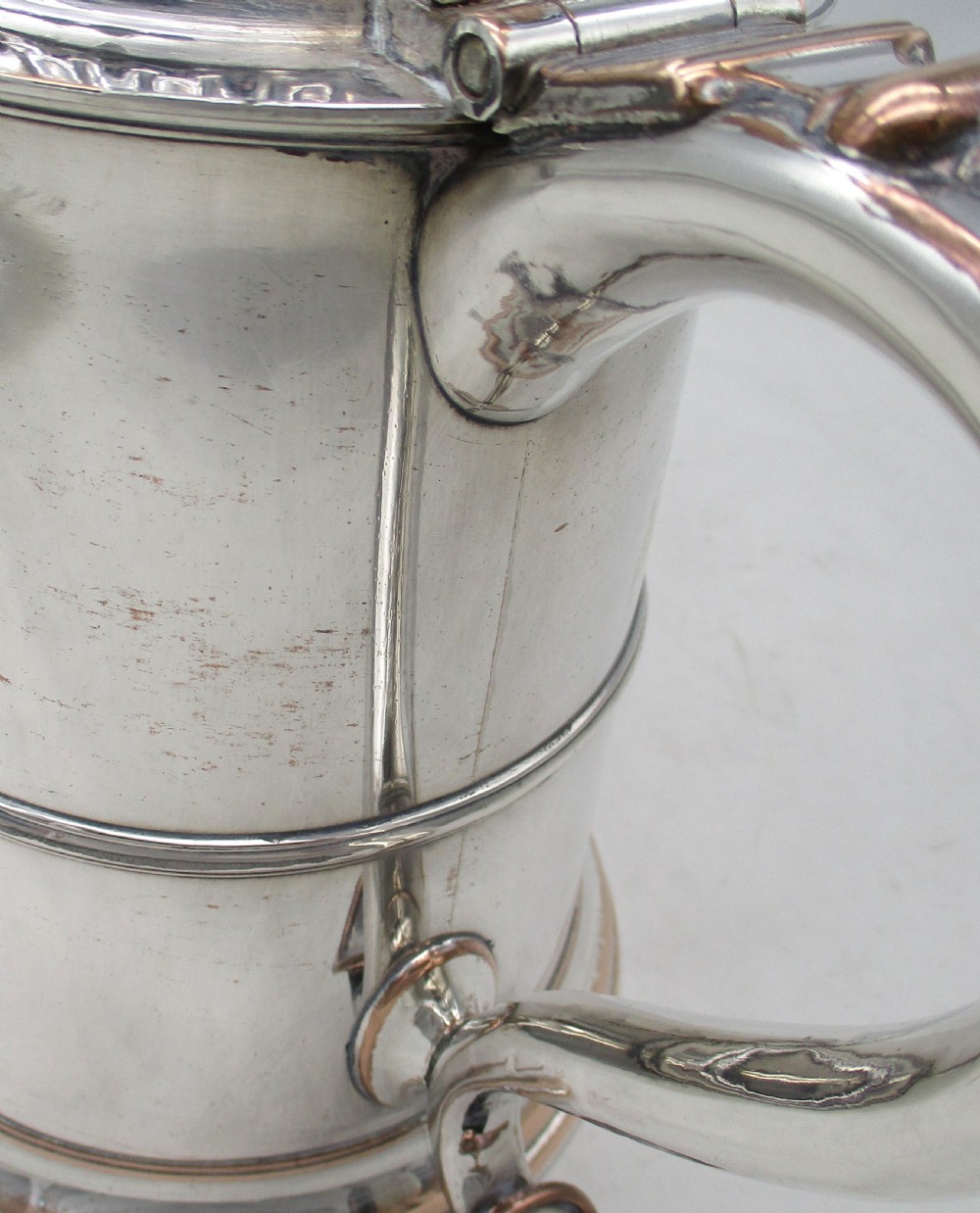 A Georgian Old Sheffield plated silver tankard featuring a domed gadrooned lid, sturdy scroll handle, and subtle copper show-through along the base. View V