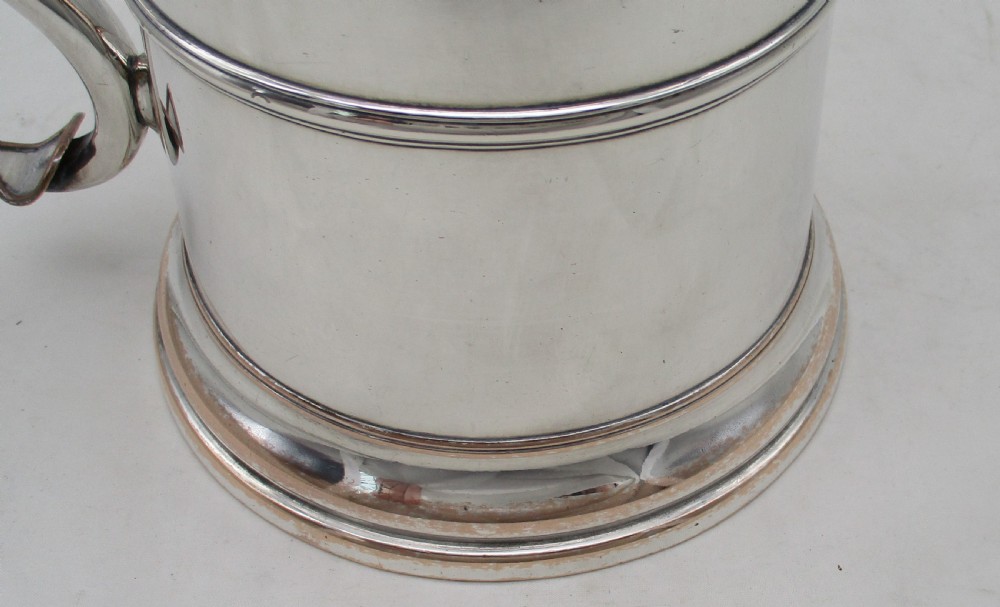 A Georgian Old Sheffield plated silver tankard featuring a domed gadrooned lid, sturdy scroll handle, and subtle copper show-through along the base. View VI
