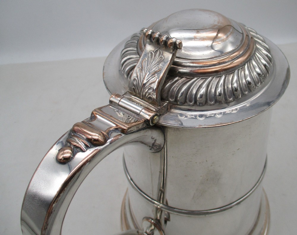 A Georgian Old Sheffield plated silver tankard featuring a domed gadrooned lid, sturdy scroll handle, and subtle copper show-through along the base. View VII