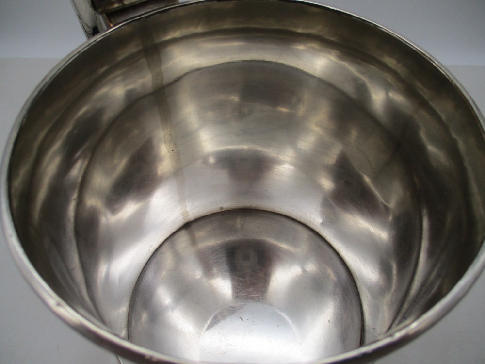 A Georgian Old Sheffield plated silver tankard featuring a domed gadrooned lid, sturdy scroll handle, and subtle copper show-through along the base. View IX