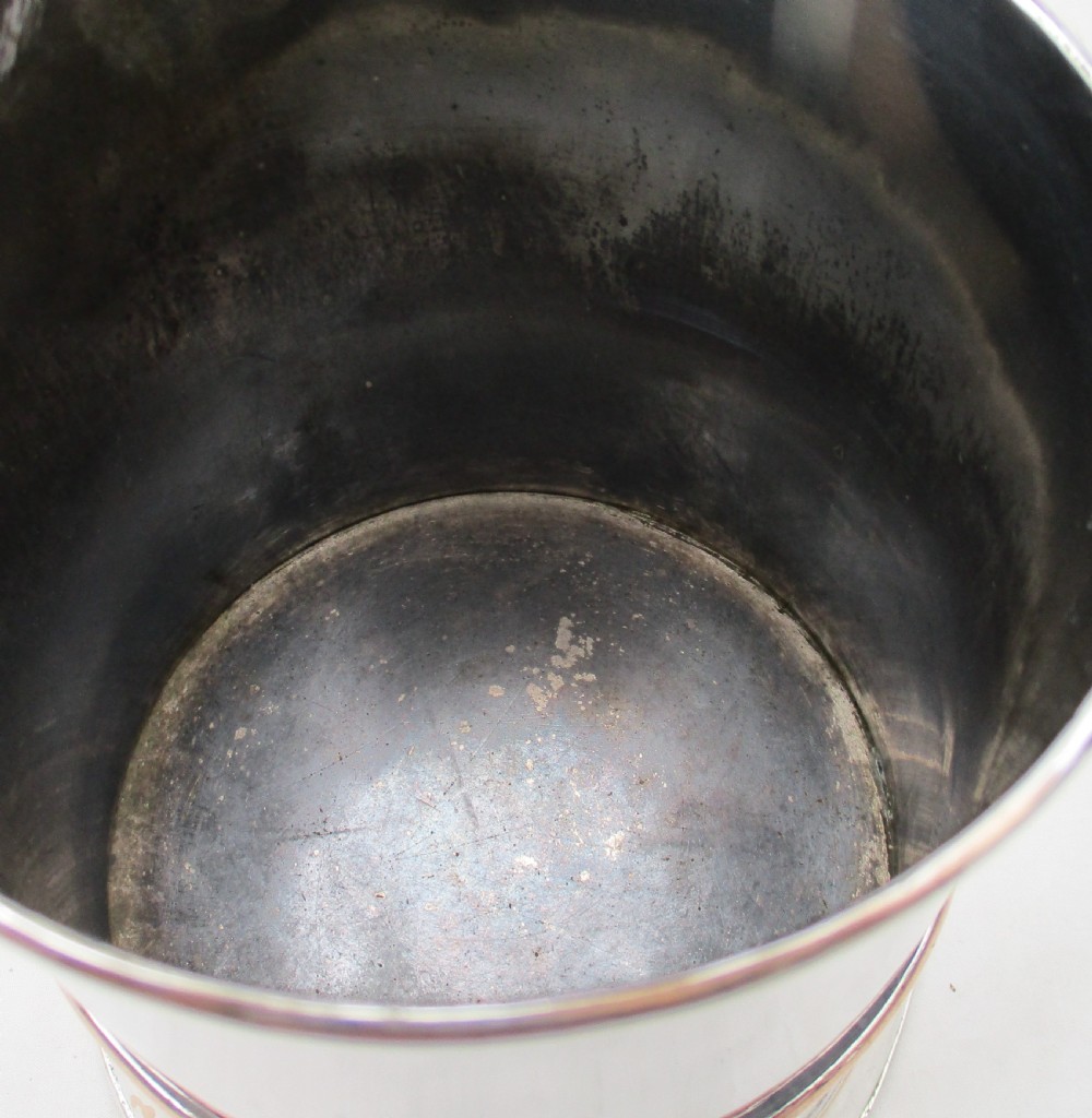 An antique silver-plated lidded tankard showing copper exposure along the rims, featuring a hinged domed lid, thumbpiece, and scroll handle. View VI