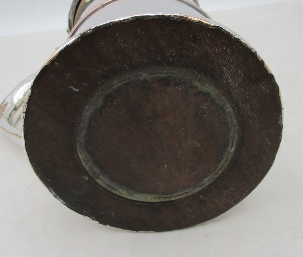 An antique silver-plated lidded tankard showing copper exposure along the rims, featuring a hinged domed lid, thumbpiece, and scroll handle. View VIII