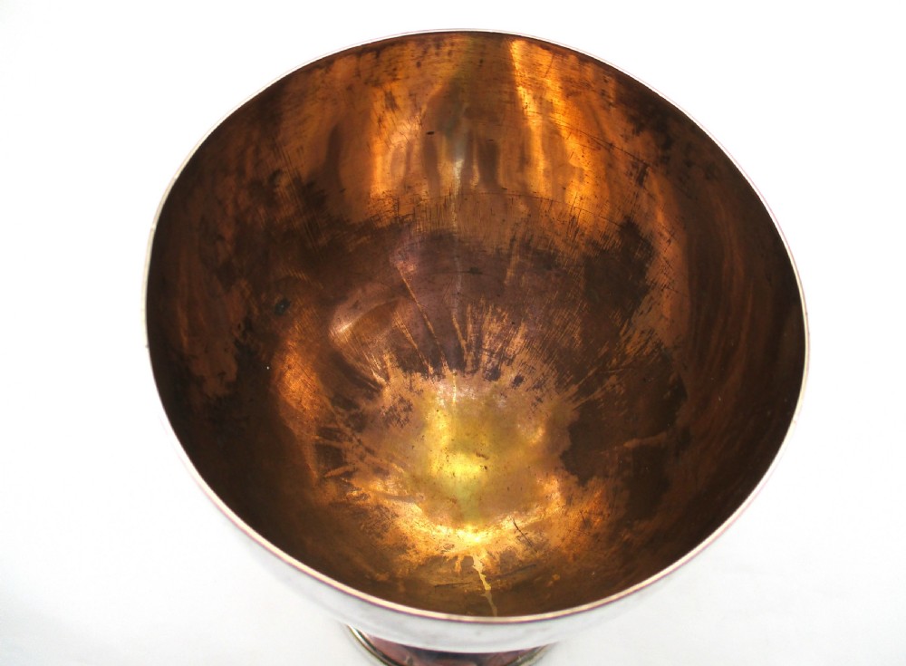 An eighteenth-century Old Sheffield plated silver goblet featuring an engraved heraldic crest, a tapered stem, and a round pedestal foot with visible copper bleeding. View III