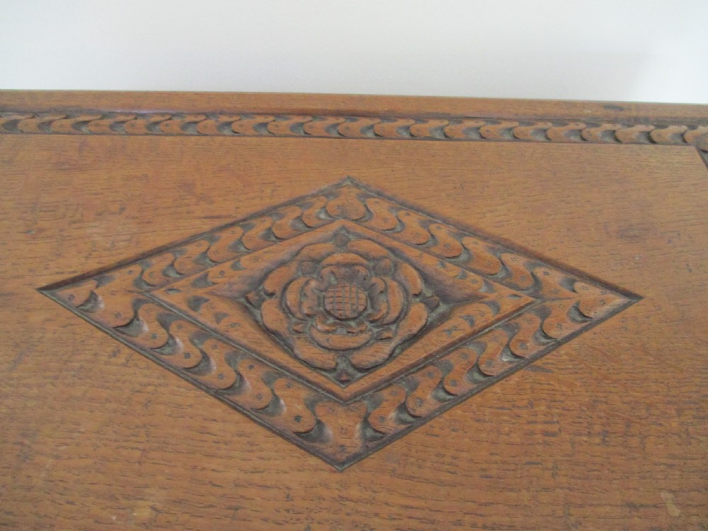 A rectangular carved oak box featuring a flat hinged lid with a carved central lozenge motif, carved borders, and a dark iron lock plate on the front panel. View VIII